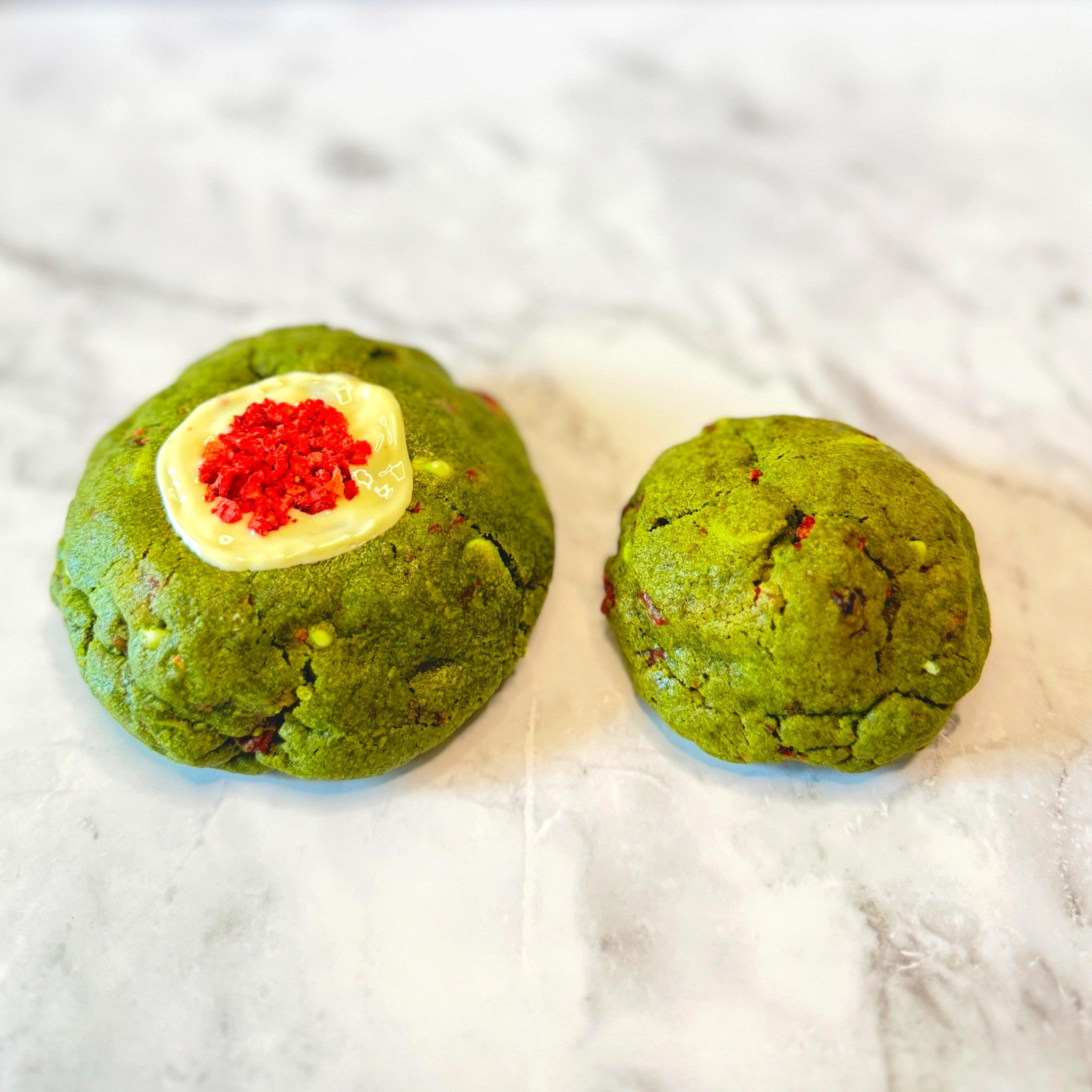 Jade Kiss Cookies: petit (3oz) next to regular (5.3oz) for a size comparison on a marble countertop.