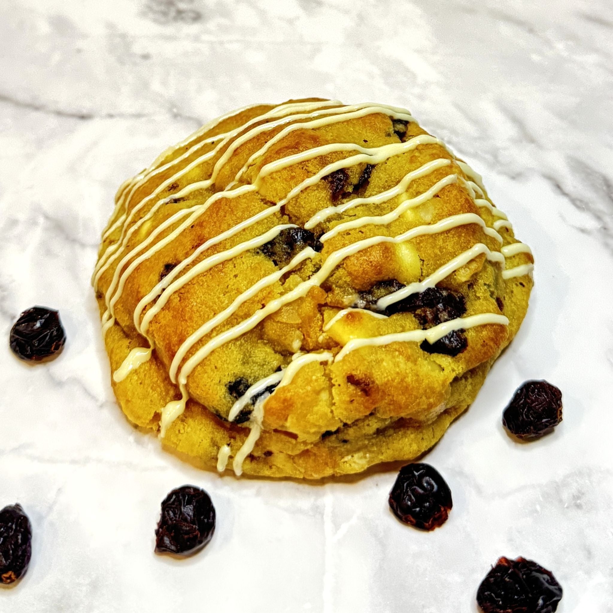 Front view of a Scarlet Zest Cookie with butter macadamia nuts and creamy white chocolate blended with sweet cranberries and a hint of fresh orange zest.