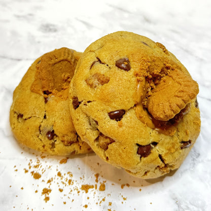 Two Amber Dusk cookies from Le Petit Cookie stacked on top of each other on a marble countertop.