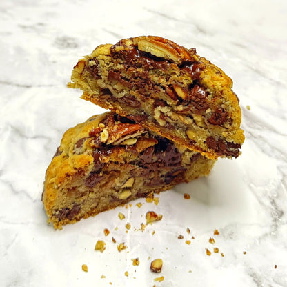 Golden Banane Cookie cut in half and stacked, showcasing the smooth chocolate center and crushed candied pecans.