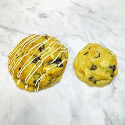 Scarlet Zest Cookies: petit (3oz) next to regular (5.3oz) for size comparison on a marble countertop.
