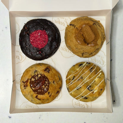 Monique’s Favorites Cookie Box containing four cookies: Midnight Berry, Scarlet Zest, Golden Banane, and Amber Dusk, neatly arranged inside the box.